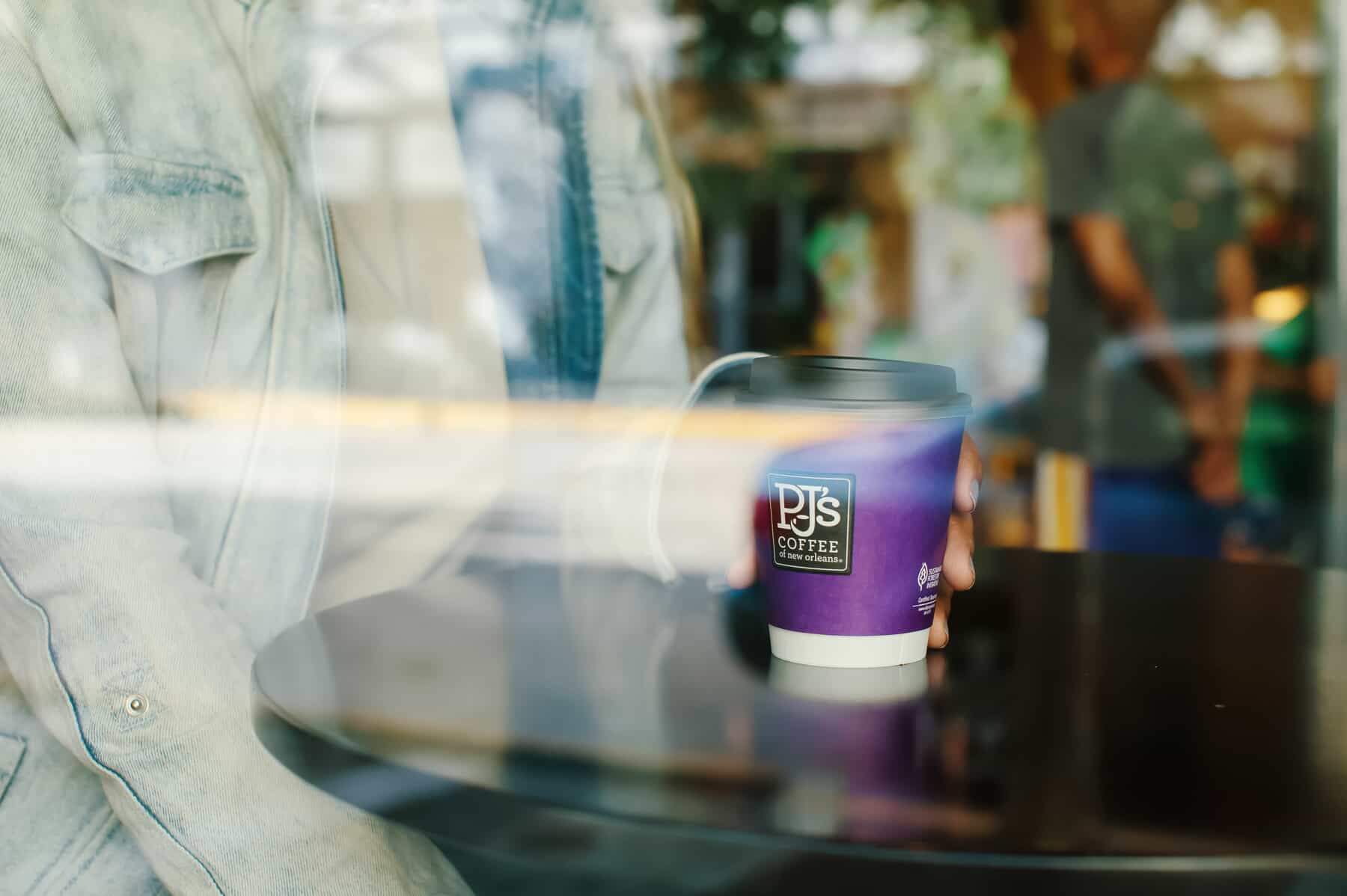 woman holding coffee to go cup