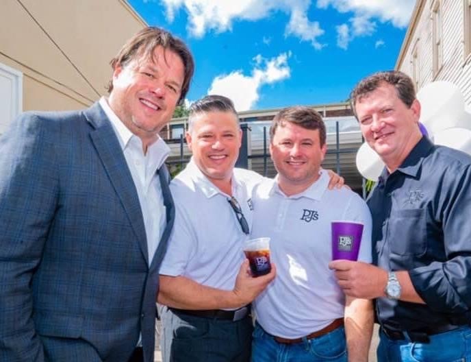 Ballard brothers smiling and holding PJ's Coffee cups