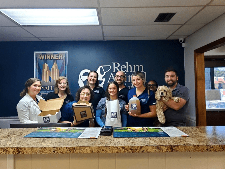 Rehm Animal Clinic employees smiling while holding PJ's Coffee items