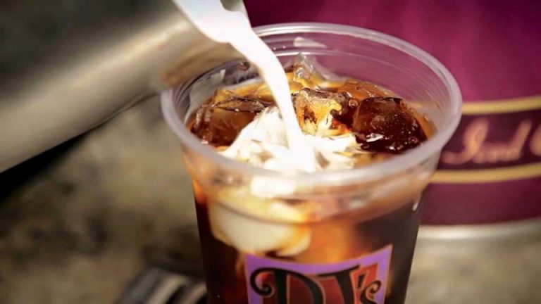 Cream being poured into a cup of cold brew from PJ's Coffee